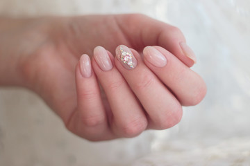 gentle pink manicure with rhinestones on the middle finger