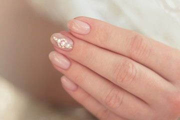 pink manicure with rhinestones on the middle finger close-up