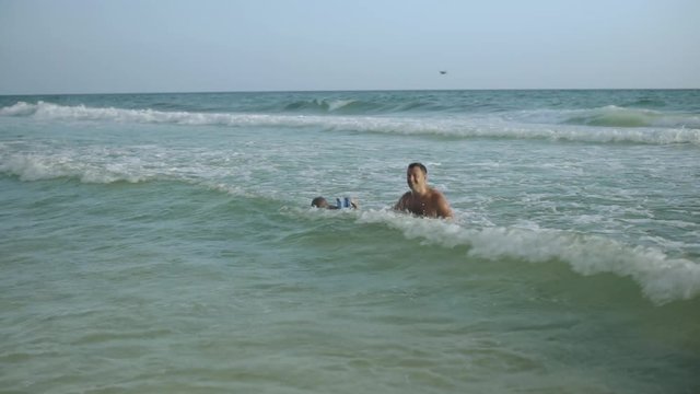 Young father and his little son have fun in the ocean 4k