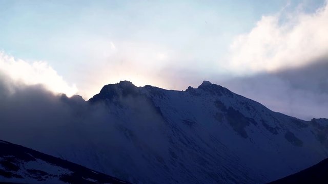 Sunset view of the peak of nevado de toluca volcano after a heavy snowfall with beautiful shadows and clouds and a relaxing atmosphere around the peak