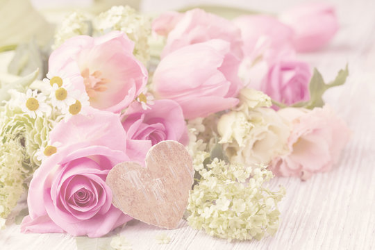 Beautiful spring flowers with wooden heart