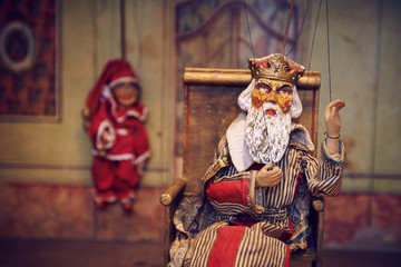 Fototapeta na wymiar Handmade wooden puppet theater. King and Jester. Selective focus