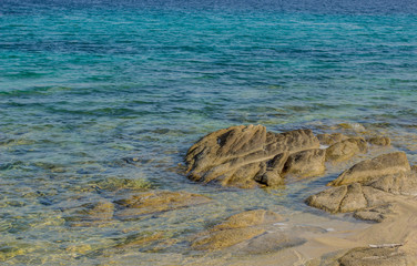 stones in vivid blue transparent sea water beach shore line south Mediterranean landscape