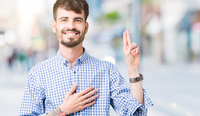 Young handsome business man over isolated background Swearing with hand on chest and fingers,...