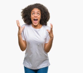 Young afro american woman over isolated background crazy and mad shouting and yelling with aggressive expression and arms raised. Frustration concept.