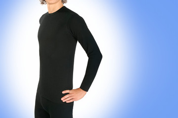 Male black thermal underwear for active winter sport. Man wearing Thermolinen on blue background....