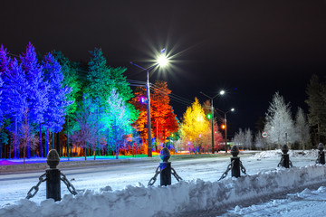 fabulous colorful forest at night,illuminated by lights on the side of the road