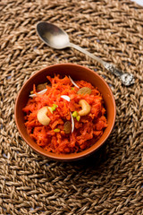 Gajar ka halwa is a carrot-based sweet dessert pudding from India. Garnished with Cashew/almond nuts. served in a bowl.