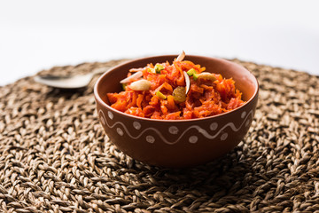 Gajar ka halwa is a carrot-based sweet dessert pudding from India. Garnished with Cashew/almond nuts. served in a bowl.