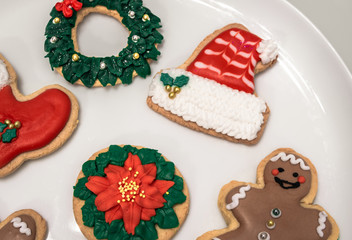 Traditional christmas cookies with different shapes: santa hat and boot, christmas wreath, happy man... Homemade biscuits with festive decoration.