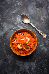 Gajar ka halwa is a carrot-based sweet dessert pudding from India. Garnished with Cashew/almond nuts. served in a bowl.