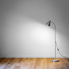 Fototapeta na wymiar metal floor lamp in empty room with shadow on white wall and copy space for text
