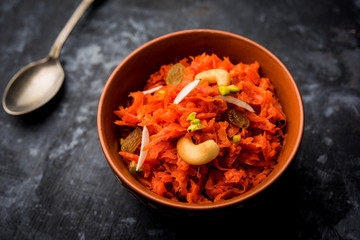 Gajar ka halwa is a carrot-based sweet dessert pudding from India. Garnished with Cashew/almond nuts. served in a bowl.