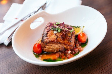 Baked juicy chicken breast and crispy skin with tomato and lemon served with white wine.