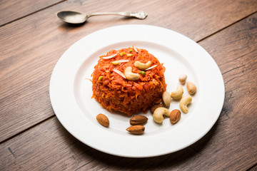Gajar ka halwa is a carrot-based sweet dessert pudding from India. Garnished with Cashew/almond nuts. served in a bowl.