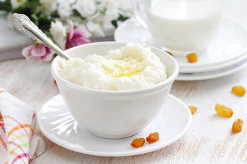 Sweet rice porridge with butter and mug of milk
