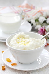 Obraz na płótnie Canvas Sweet rice porridge with butter and mug of milk