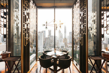 Modern luxury decorated interior restaurant that can view Bangkok cityscape. Elegant design for fine dining.
