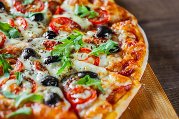 Pizza Margherita or Margarita with Mozzarella cheese, tomato, olive. Italian pizza on wooden background