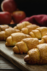 Fresh baked croissants on a wooden stand.
