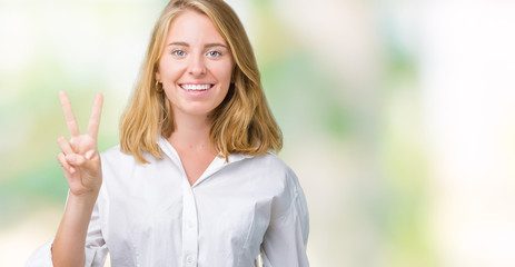 Fototapeta premium Beautiful young business woman over isolated background showing and pointing up with fingers number two while smiling confident and happy.