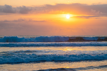 Big waves during sunset on the ocean Kuta beach of Bali island, Indonesia