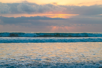 Fototapeta na wymiar Big waves during sunset on the ocean Kuta beach of Bali island, Indonesia