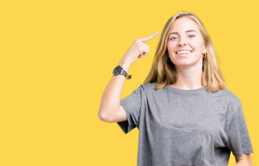 Beautiful young woman wearing oversize casual t-shirt over isolated background Smiling pointing to head with one finger, great idea or thought, good memory