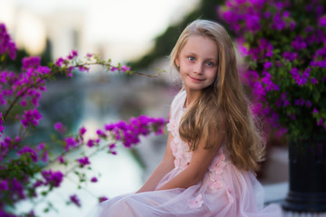 Portrait of a cute beautiful girl in princess dress in blooming gardens