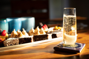 Champagne flute with desserts in the background and space for text