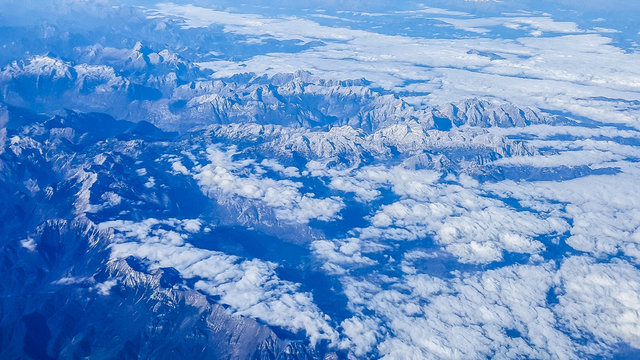 Fototapeta The view from the airplane illuminator on Alps.