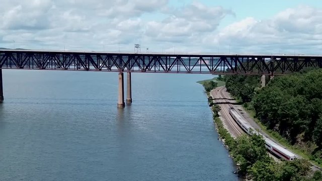 A Metro-North Railroad train travels along the Hudson River and under the Newburgh-Beacon Bridge in Beacon, New York.
