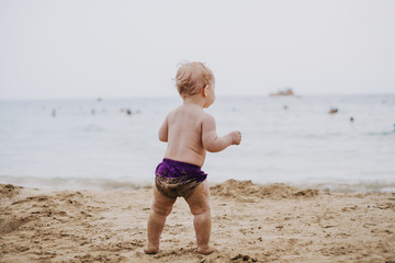 ребенок ходит по песку на пляже a child walks on the sand on the beach