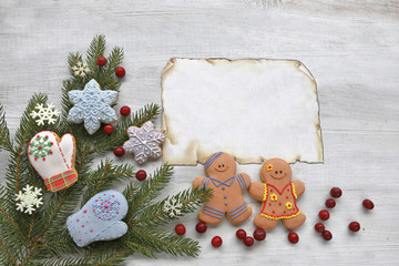 Gingerbread  man with christmas tree and paper  on wooden background 