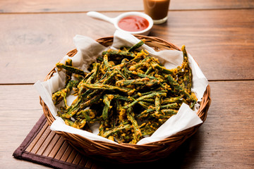 Kurkuri bhindi or crispy ladyfinger or okra fry recipe, served in a bowl with ketchup and hot tea....