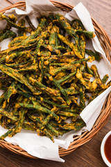 Kurkuri bhindi or crispy ladyfinger or okra fry recipe, served in a bowl with ketchup and hot tea....