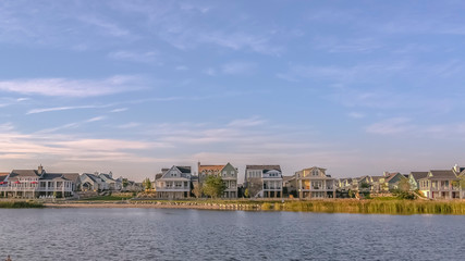 Fototapeta premium Clouds and blue sky over homes and Oquirrh Lake