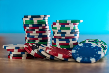 Fototapeta na wymiar Casino chips on wooden table with blue background
