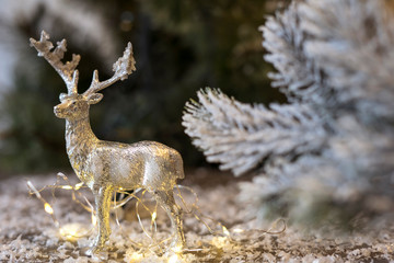 Naklejka na ściany i meble Decorative silver deer on the background of the Christmas tree.