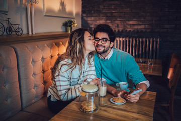  Beautiful loving couple sitting in a cafe drinking coffee and conversating. Love and romance concept.