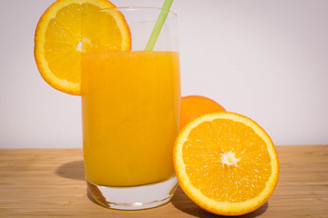 Healthy orange juice with half orange on wood table