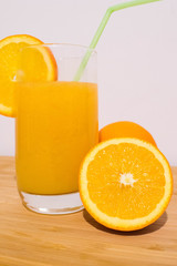Healthy orange juice with half orange on wood table