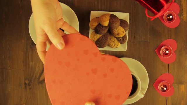 Young people in a cafe by candlelight give each other souvenirs.