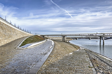 A fascinating composition of slopes, ramps, stairs and walls as well as two bridges at the bank of the new channel of the river Waal near Nijmegen, The Netherlands, on a sunny day in winter