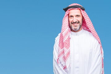 Senior arab man wearing keffiyeh over isolated background with a happy and cool smile on face....