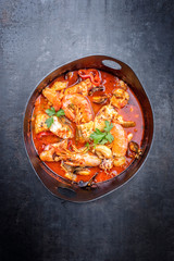 Traditional America cajun fish stew with prawns, mussels and fish as top view in a modern design...