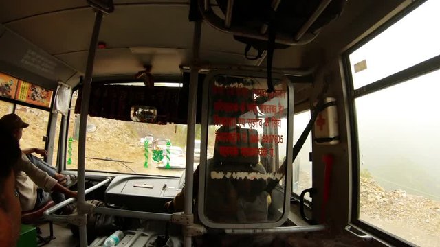 View through moved bus with driver on mountain road in Himalaya