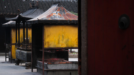 View onto a backyard with yellow candle and incence containers in a historic temple in Suzhou, China, Asia