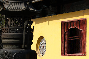 Incence bowl infront of the yellow painted main praying hall with a stone and wooden window in a buddhist temple in Suzhou, China, Asia