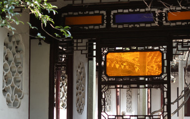Stone windows and decorative hallway frames with colored glass in a historical garden in the old town of Suzhou city, China, Asia